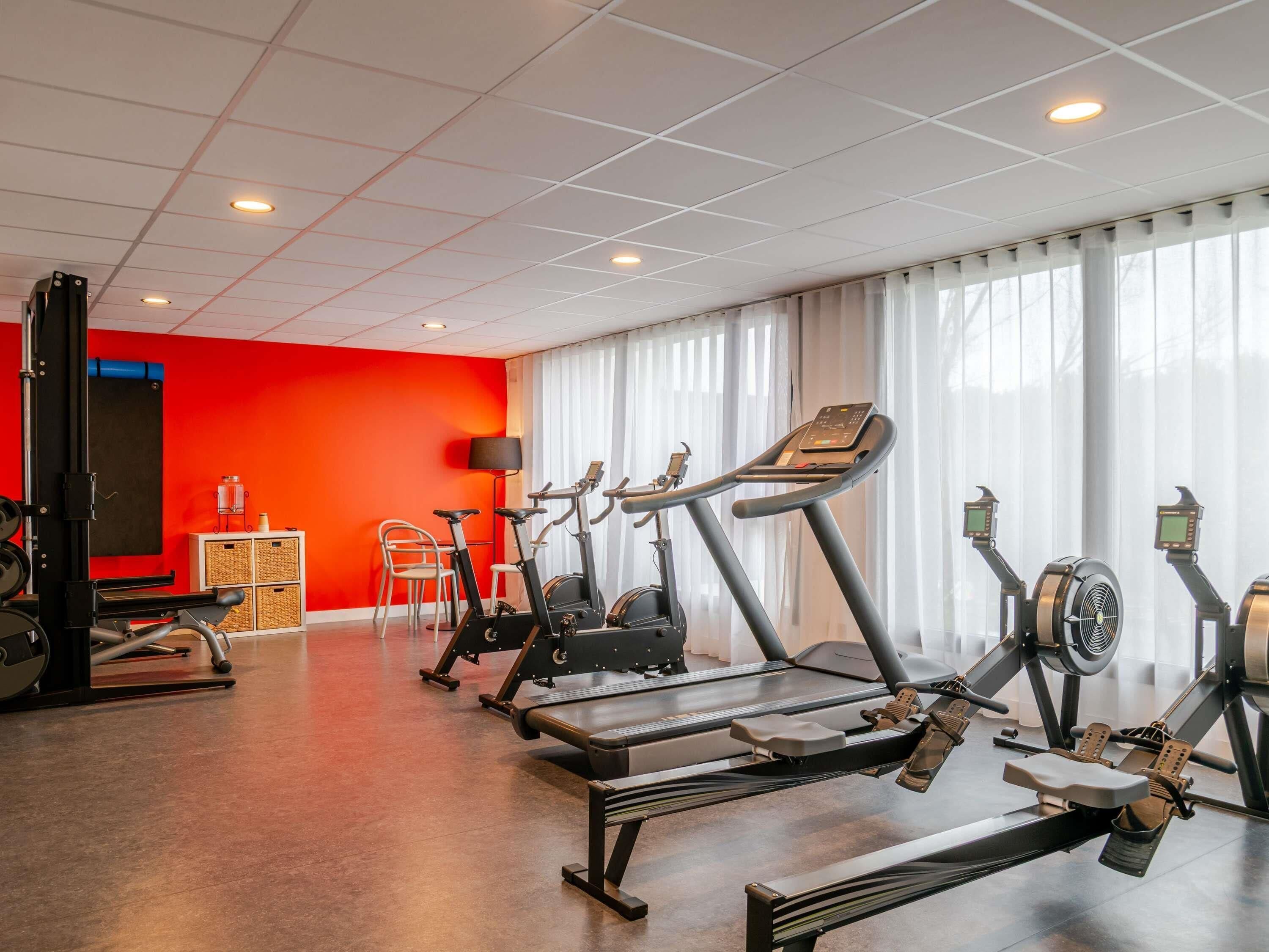 A gym with treadmills, stationary bikes, and a rowing machine.