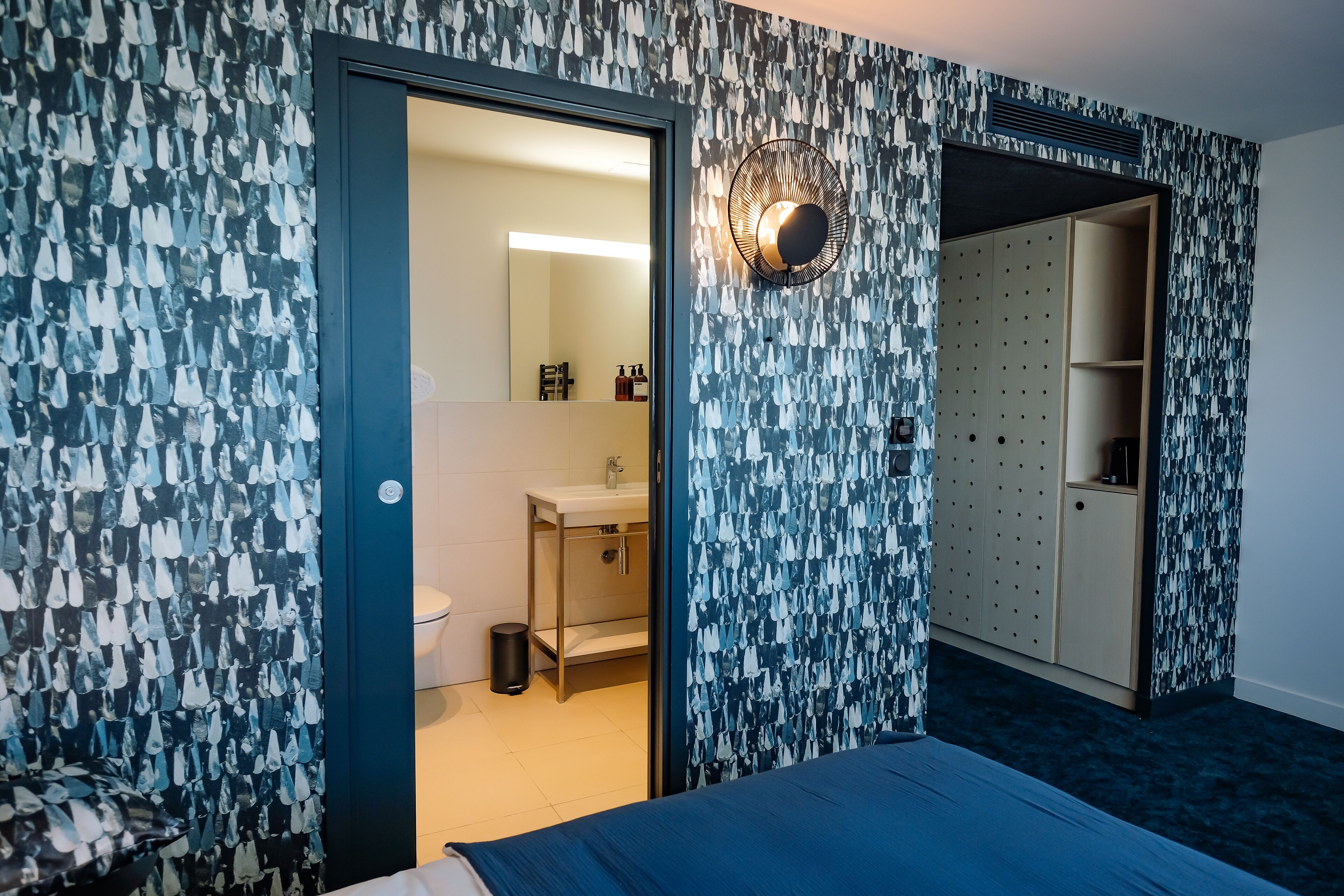 Ein Hotelzimmer mit Bett, Bad mit Waschbecken und Toilette sowie einem Kleiderschrank.