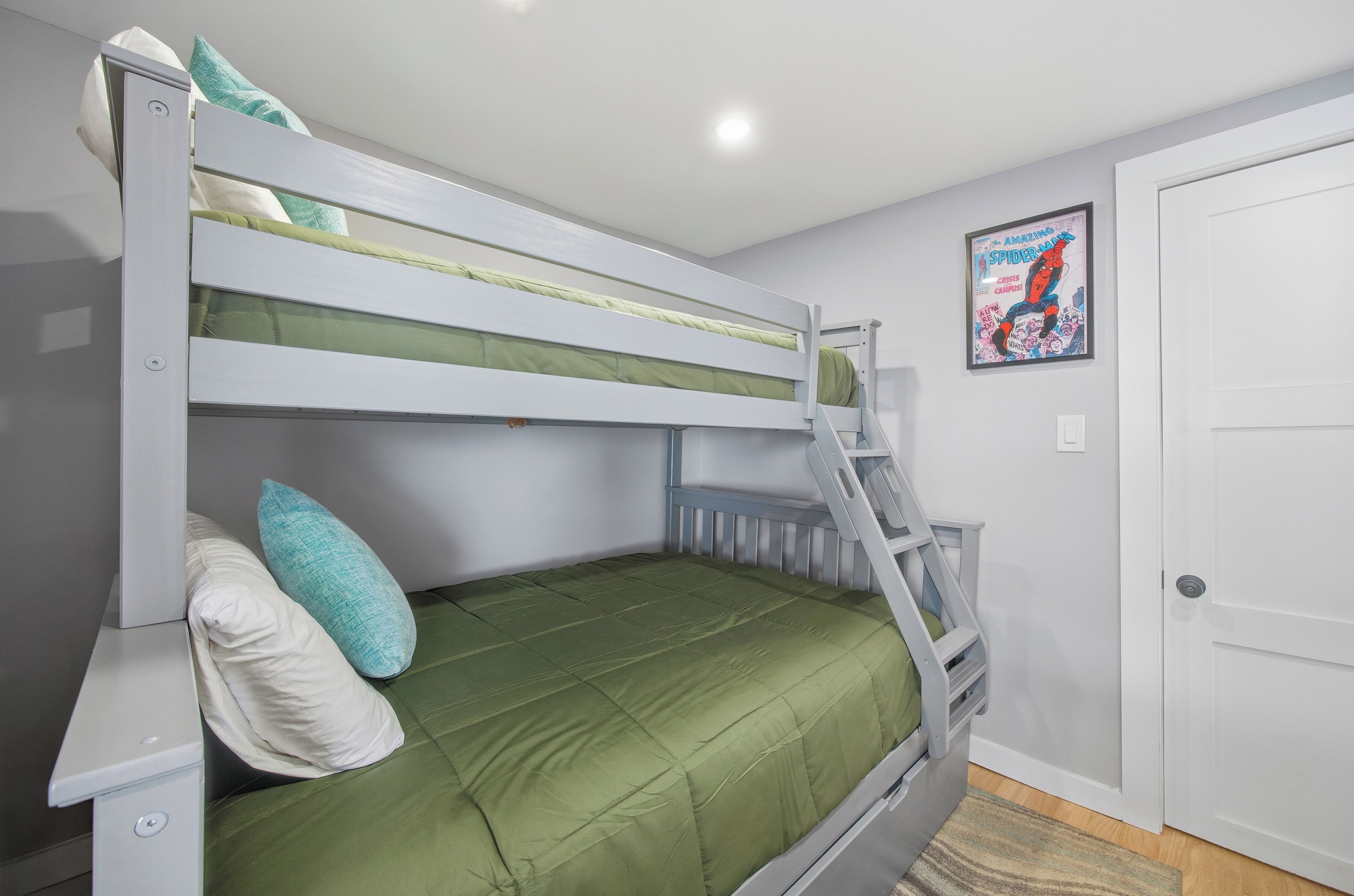 Una cama nido con escalera, un colchón verde y un cartel en la pared.