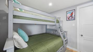 Ein Stockbett mit einer Leiter, einer grünen Matratze und einem Poster an der Wand.