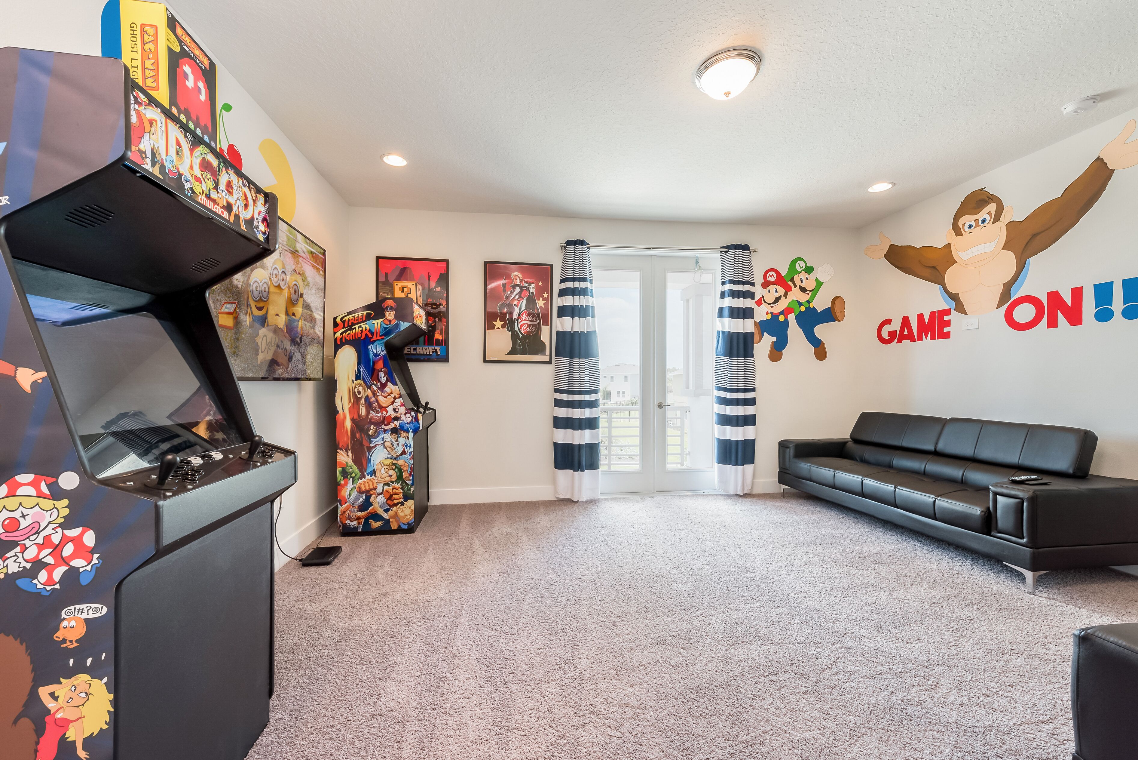 Una habitación con una consola de videojuegos, un sofá y decoraciones en la pared que incluyen a los personajes Mario y Luigi.