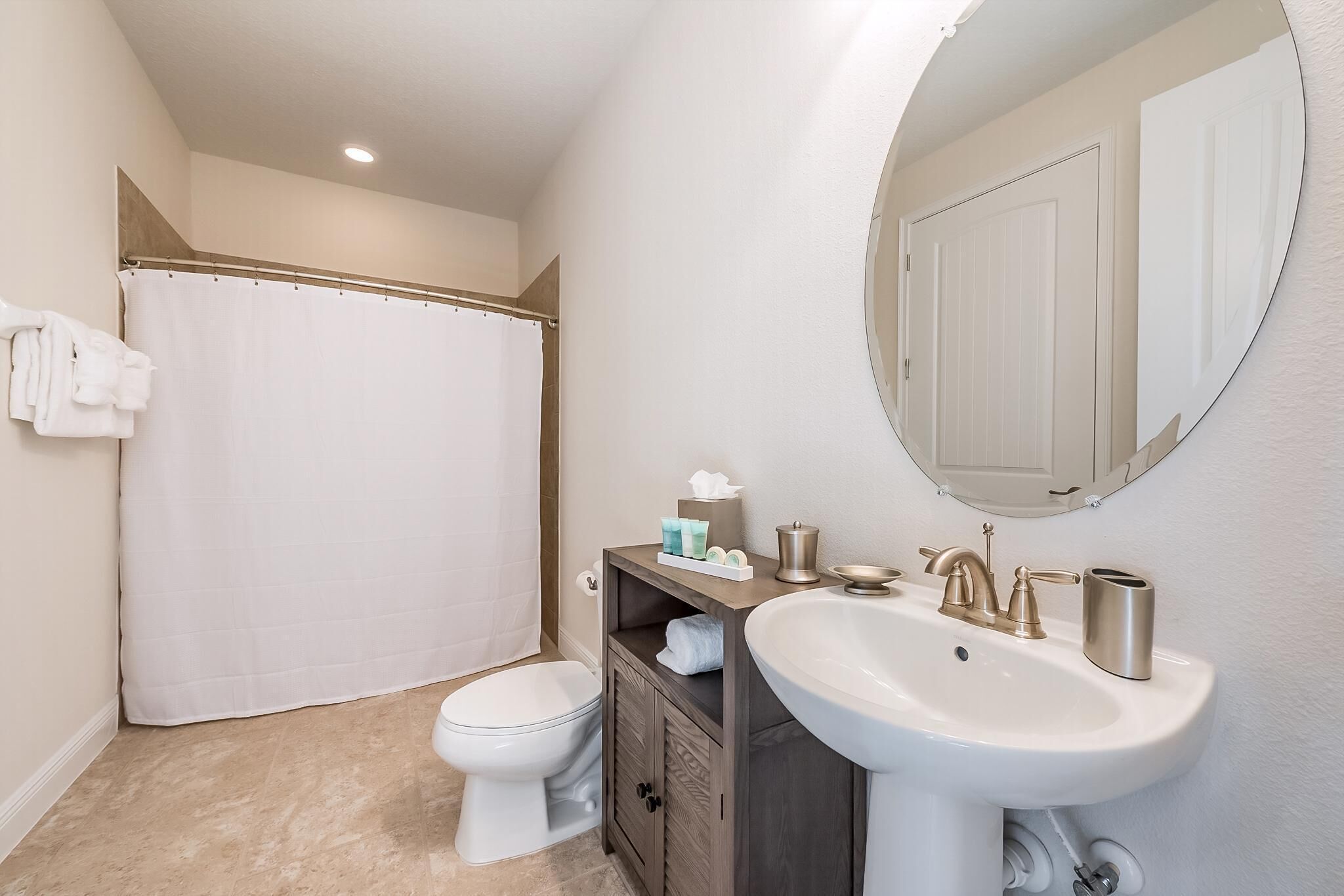 A bathroom with a toilet, sink, and shower curtain.