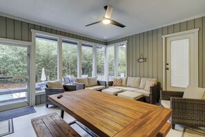Relax in this serene space with a large table and wicker chairs, offering views of the surrounding greenery.
