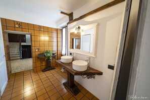 A bathroom with two sinks, a mirror, and a wooden vanity. - Casa Olmi (Centro Valle Intelvi)