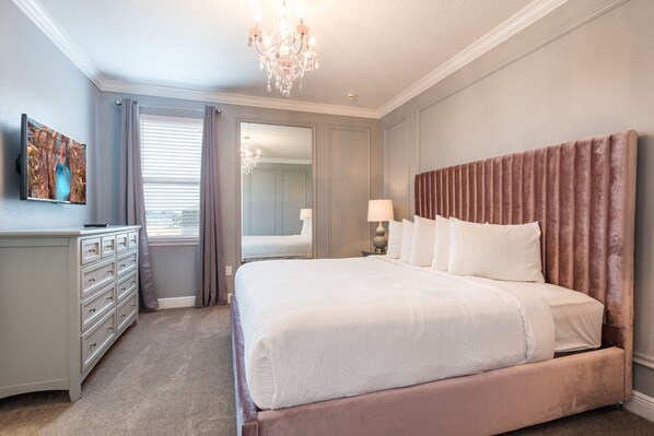 A bedroom with a large bed, a dresser, a mirror, and a chandelier. - Gorgeous Home near Disney: Private Pool, Themed Rooms & Waterpark - 7687FF (Reunion)