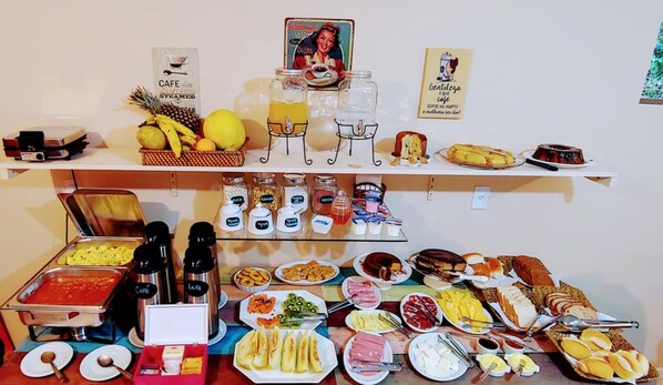 Una barra de buffet con diversos alimentos, salsas y bebidas.