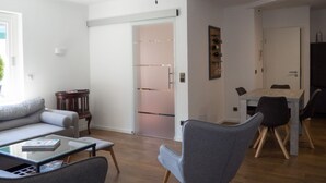 Ein modernes Wohnzimmer mit einer Couch, einem Couchtisch und einem Essbereich mit Stühlen und einem Tisch.