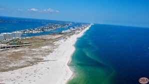 A coastal resort with a beachfront, a marina, and a large hotel complex.