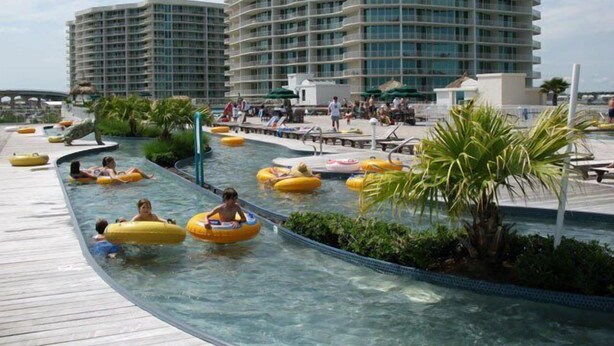A swimming pool area with multiple levels of balconies and a water slide.