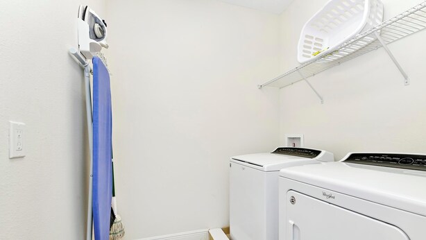 A laundry room with a mopping machine, a washing machine, and a drying rack.