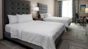 A hotel room with two beds, a desk, a chair, and a large window with curtains. - Homewood Suites by Hilton Greensboro Wendover, NC (Greensboro)