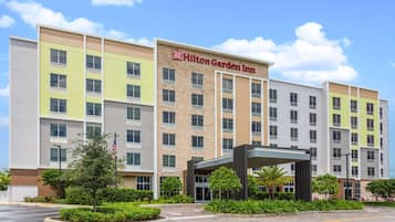 Hotel entrance with a covered walkway and landscaped surroundings.
