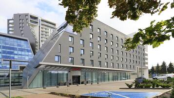 Un hotel modern amb teulada plana, grans finestres i un rètol que diu 'Hampton'.