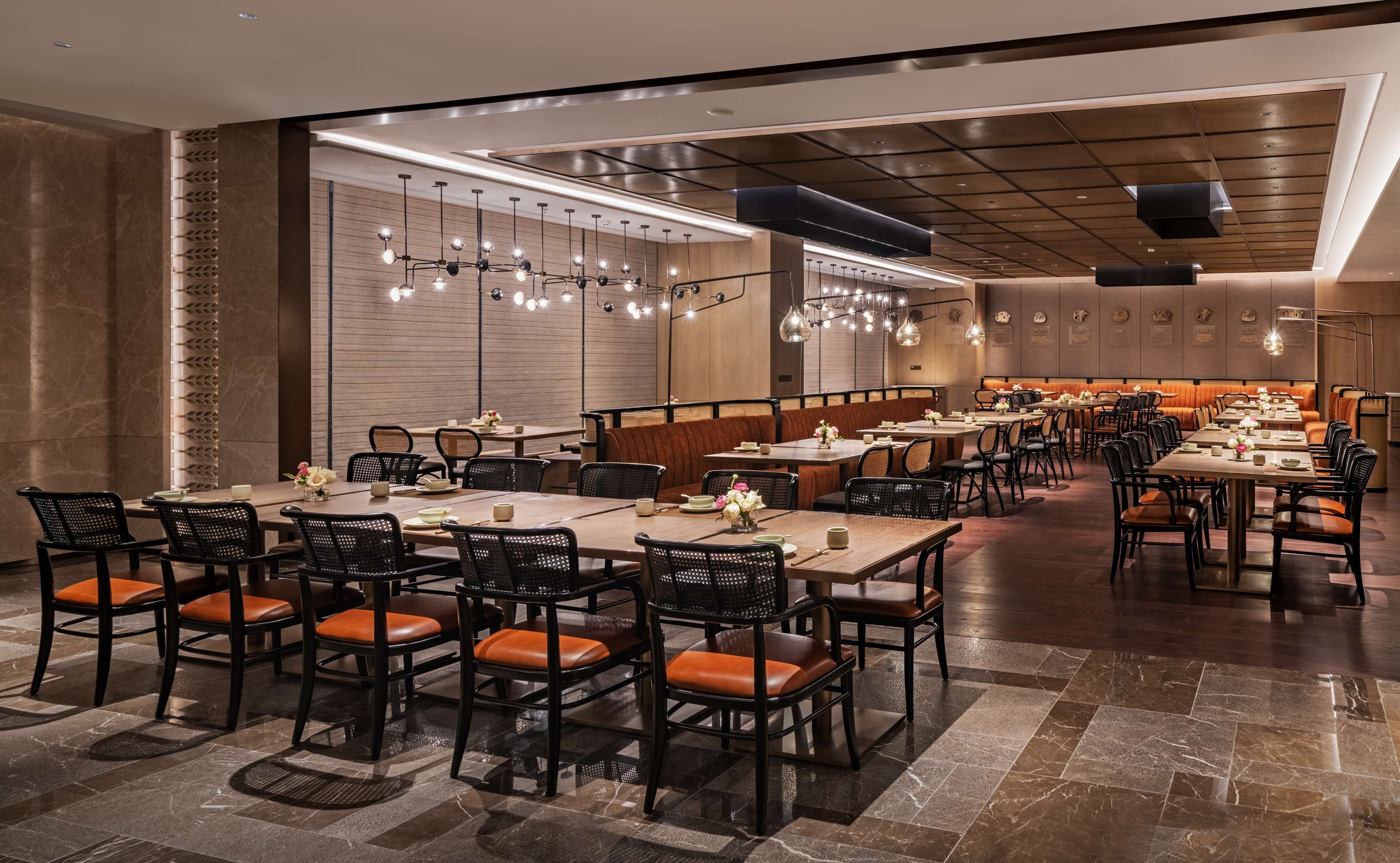 A modern restaurant with a variety of seating options, including booths and tables, and a polished stone floor.
