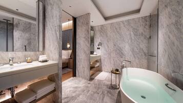 Un baño moderno con una bañera grande, un tocador con espejo y una zona de ducha.