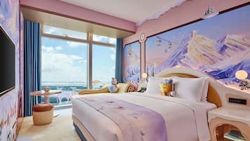 Une chambre avec un grand lit, une vue sur la ville, une fenêtre et une fresque murale.