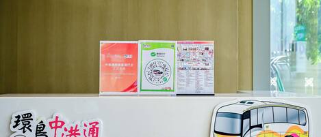 A table with informational brochures and a bus illustration.