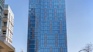 Um edifício moderno de hotel com fachada de vidro e placa indicando Hilton Garden Inn.