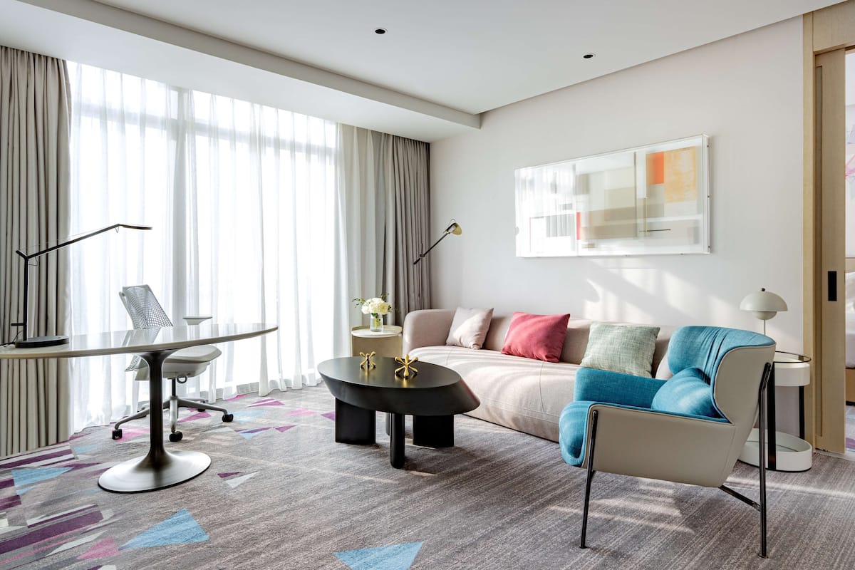 Een moderne woonkamer met een ronde glazen tafel, een bank en een salontafel.