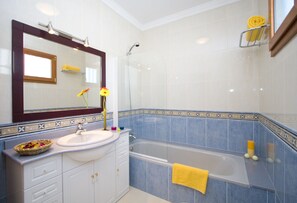 Een bad/douchecombinatie, een haardroger, een bidet, handdoeken
