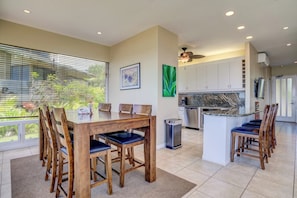 A modern kitchen with white cabinets, a granite countertop, and a built-in oven.