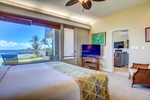 Ein Hotelzimmer mit einem großen Bett, einem Fernseher und Meerblick.