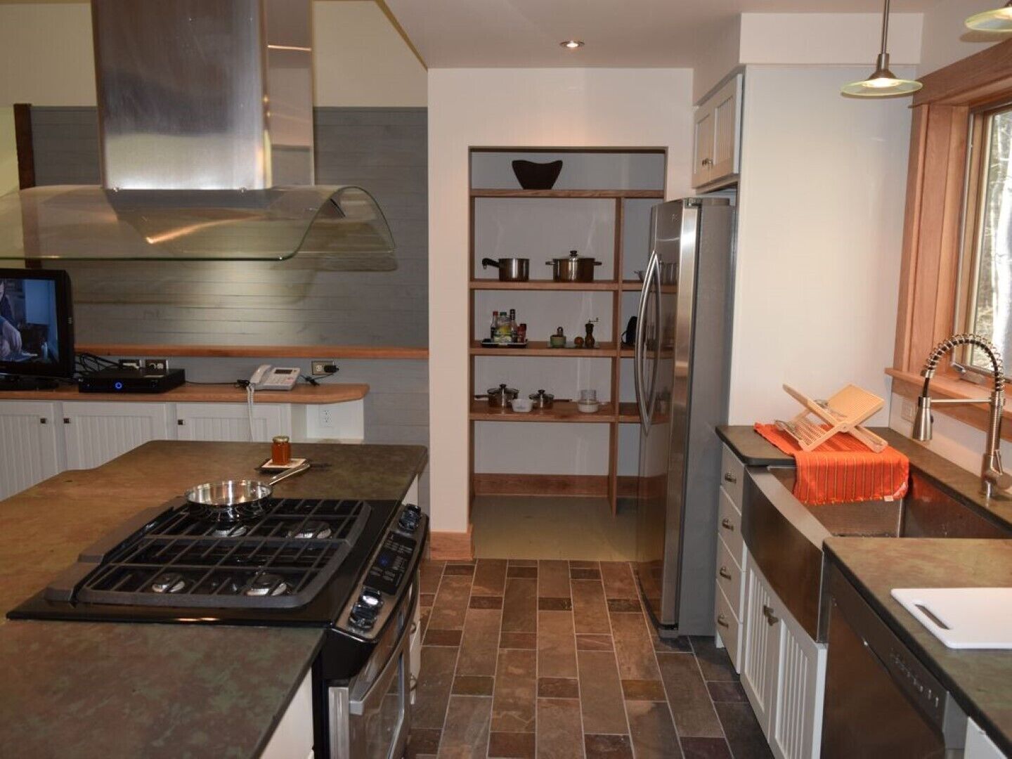 Una cocina moderna con una isla central, electrodomésticos de acero inoxidable y un horno empotrado.