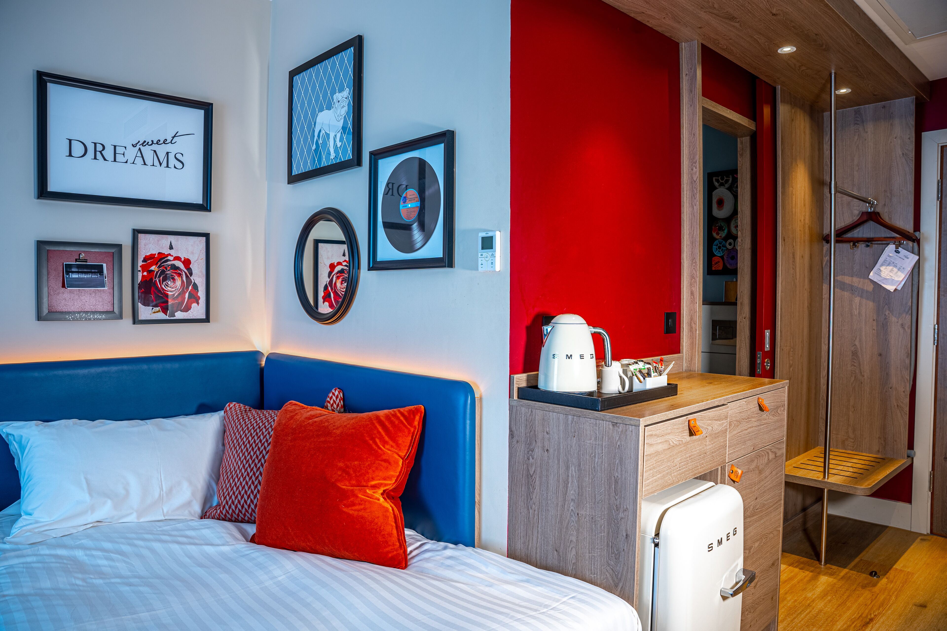 Una habitación de hotel con cama, cómoda y kitchenette.