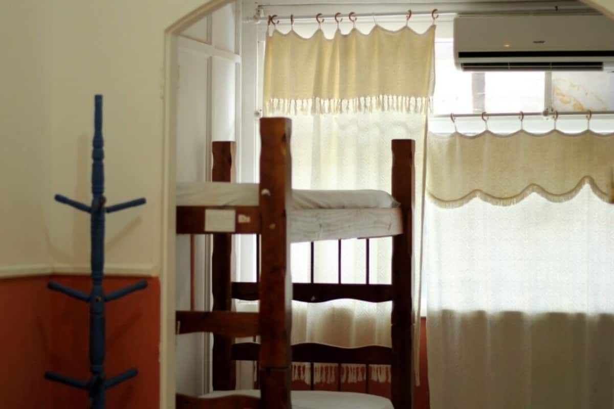 A bunk bed room with a window and curtains.