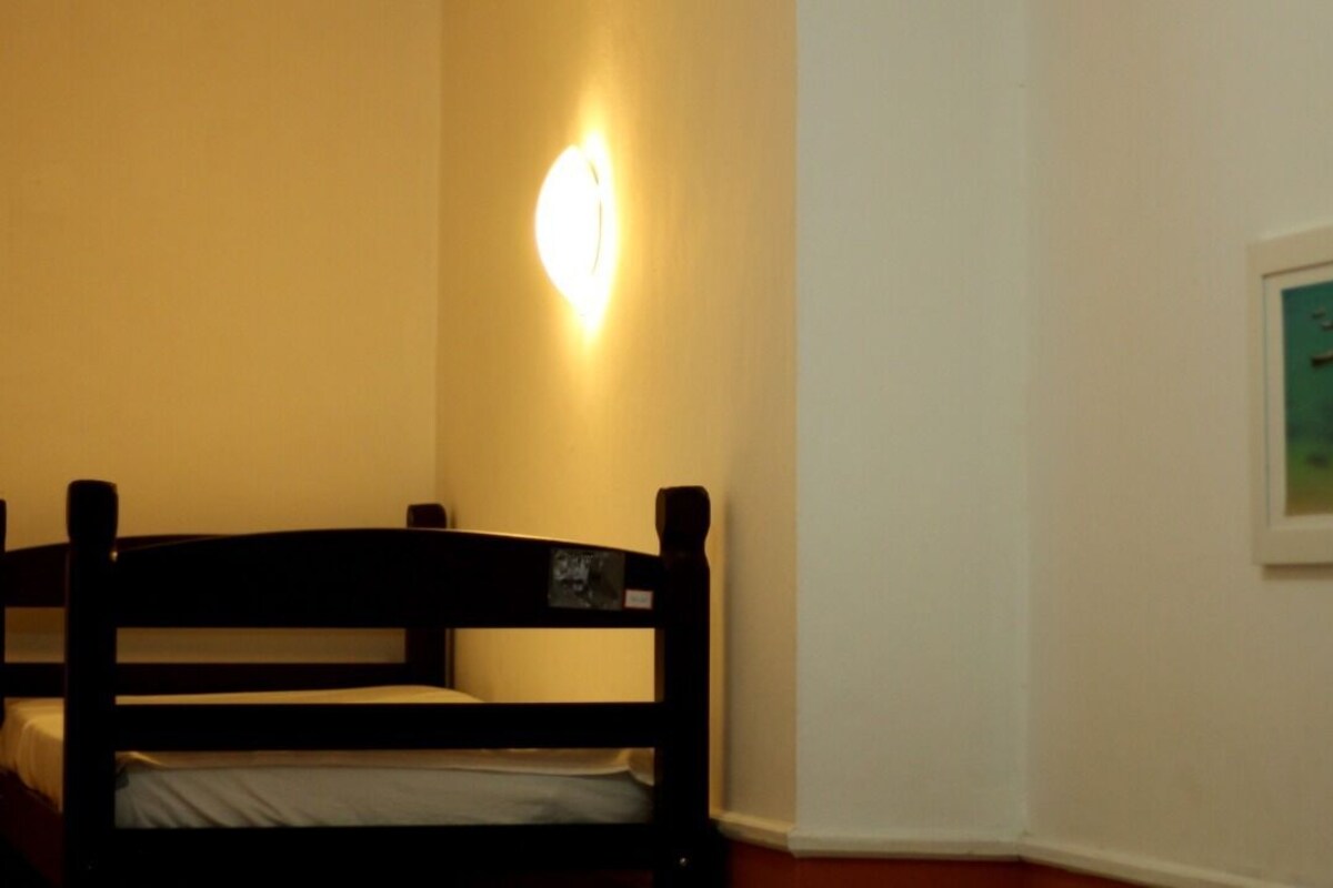 Una habitación con literas, una lámpara de pared y un cuadro enmarcado.