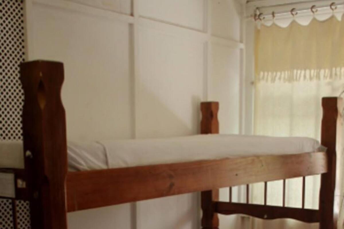 A bunk bed with a mattress and a wooden frame.