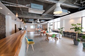 Work and relax in a spacious office with a mix of seating areas, a reception counter, and plenty of natural light.