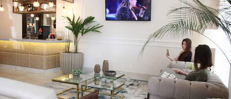 Una sala de estar moderna con una mesa de centro de vidrio, un sofá y un televisor montado en la pared.