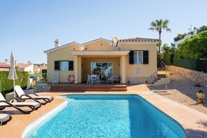 Un bâtiment à deux étages doté d’une piscine, d’un espace extérieur aménagé et d’une terrasse couverte.