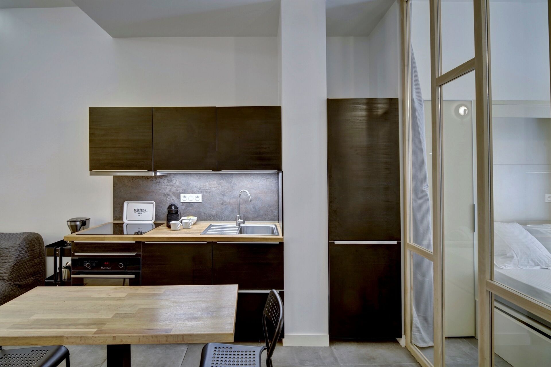 A compact kitchen with a wooden countertop, a coffee maker, and a sink.