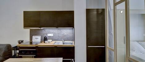 A compact kitchen with a wooden countertop, a coffee maker, and a sink.
