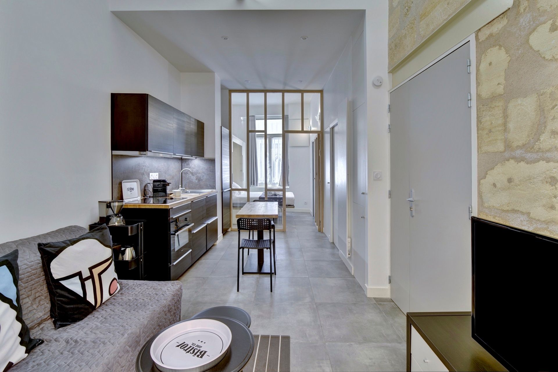 A modern apartment with a kitchenette, a dining area, and a living space.