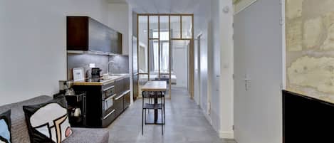 Un apartamento moderno con kitchenette, comedor y sala de estar.