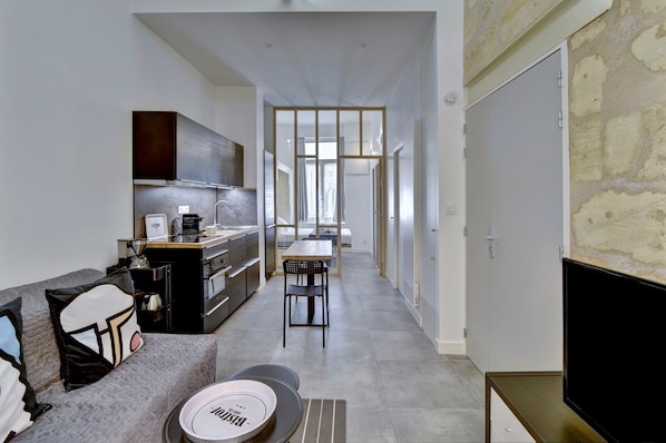 A modern apartment with a kitchenette, a dining area, and a living space.