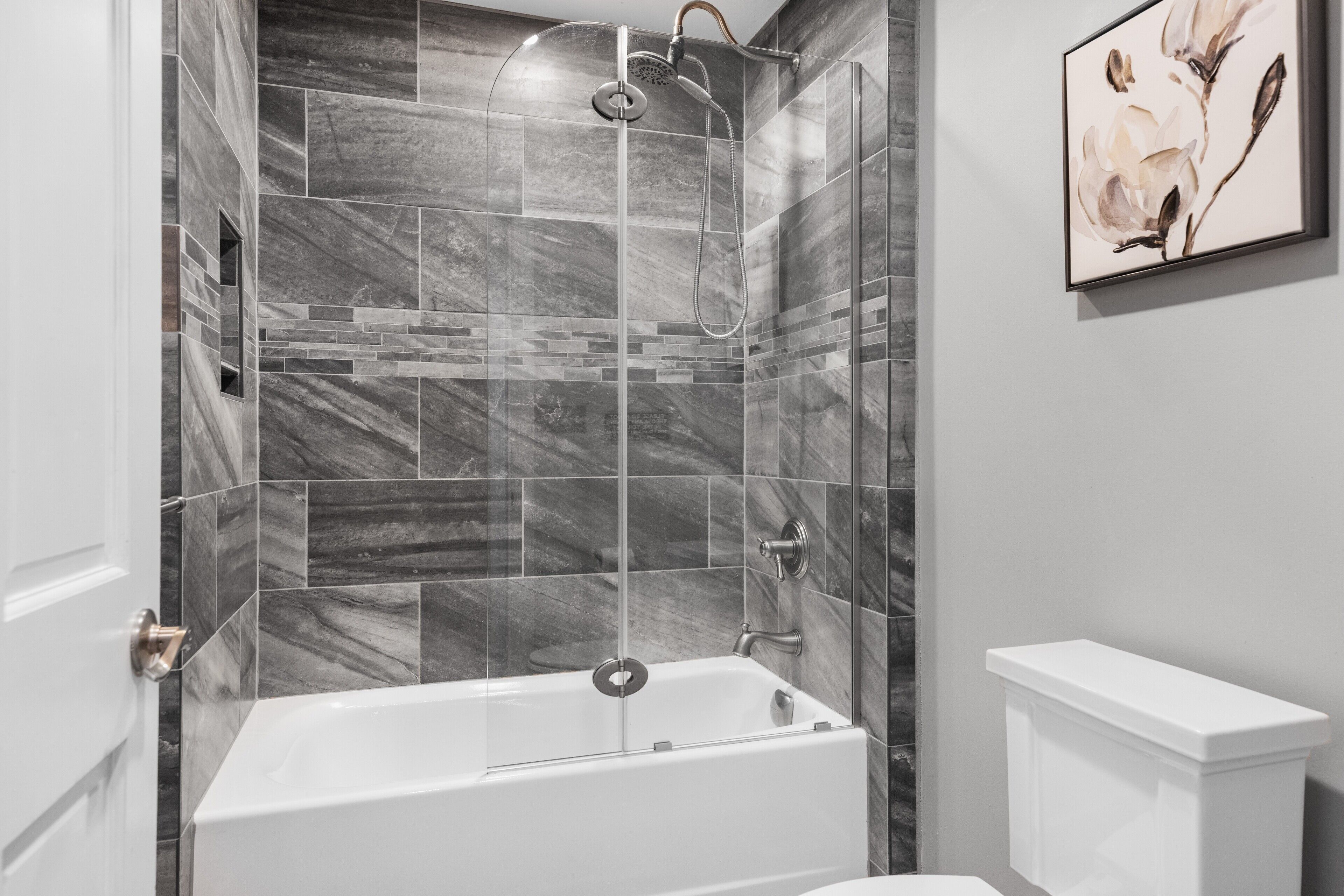 Un baño moderno con una bañera independiente, cabina de ducha y un inodoro.