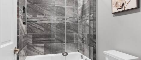 Un baño moderno con una bañera independiente, cabina de ducha y un inodoro.