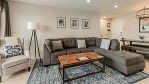 A modern living room with a sectional sofa, a coffee table, and a floor lamp. - Stylish Ski-In/Ski-Out Condo with Sunset Views and Slope Access/Sleeps 5! (Steamboat Springs)