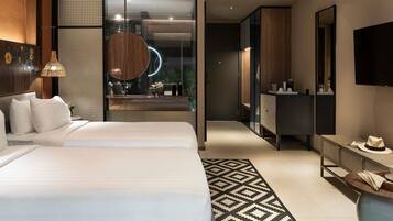 A modern hotel room with a large bed, a desk, a mirror, and a TV.