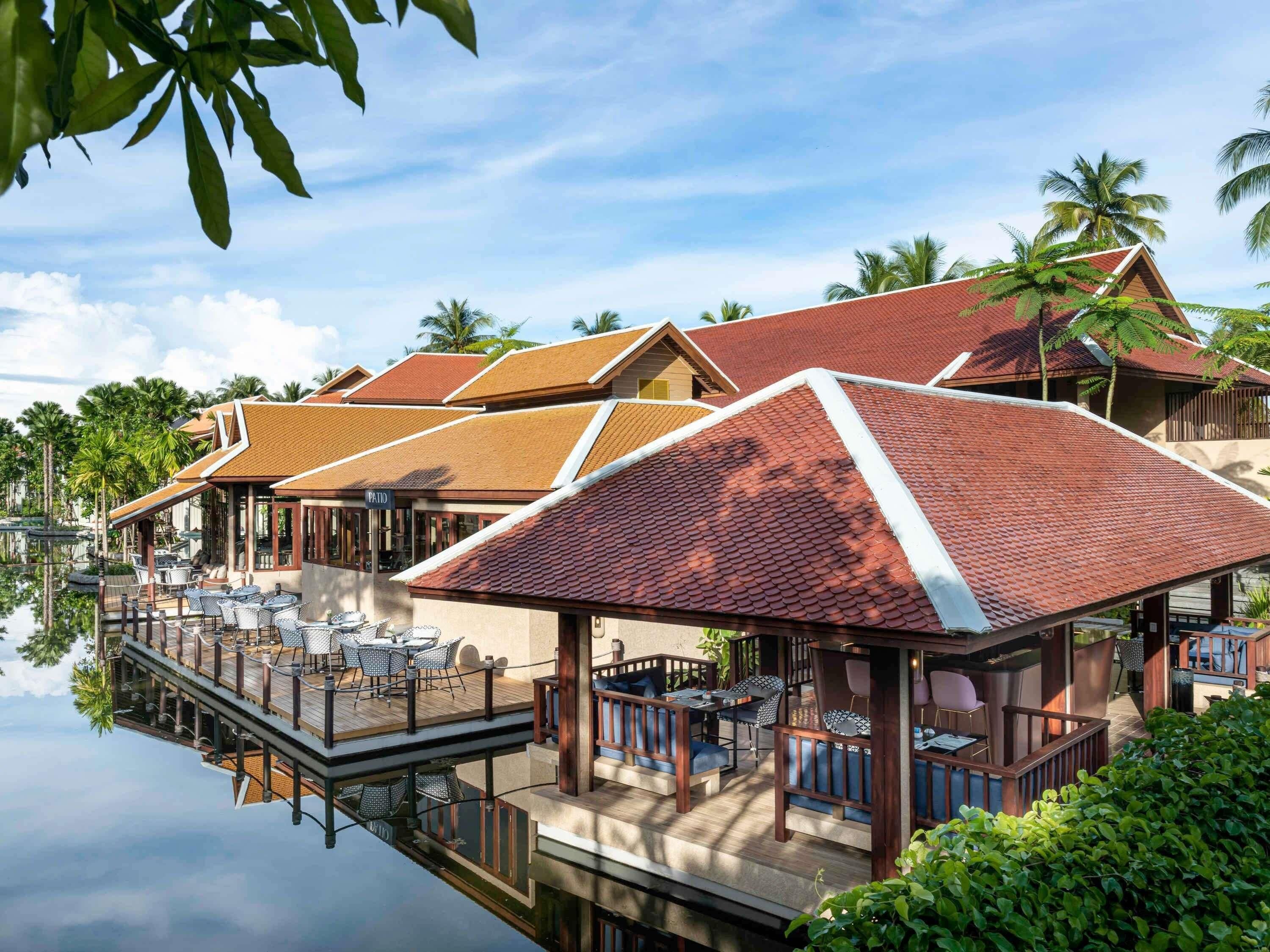 A resort with overwater bungalows, a pool, and a wooden deck.