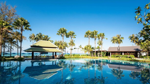 A clear blue pool with palm trees and a building with a sign that reads 'SOAK'. - Grand Mercure Khao Lak Bangsak (Takua Pa)