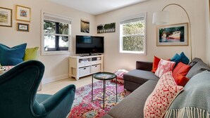 A living room with a television, sofas, a coffee table, and a patterned rug. - River Hideaway Retreat (Southport)