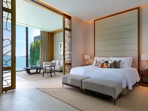 A modern hotel room with a large bed, a sofa, a dining table, and a balcony with a view of the sea. - V Villas Phuket - MGallery (Wichit)