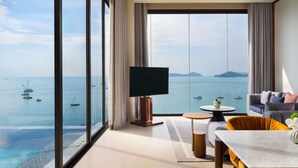 A modern hotel room with a large balcony, a flat-screen TV, a dining area, and a sofa. - V Villas Phuket - MGallery (Wichit)