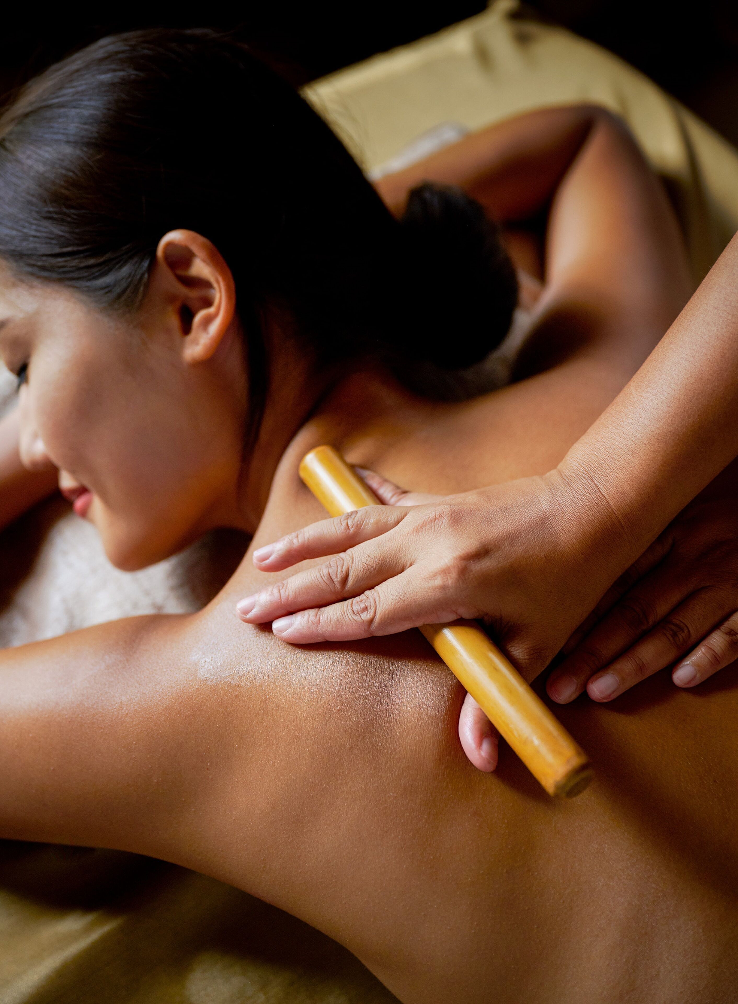 Sesión de terapia de masajes con énfasis en las manos del terapeuta y la espalda del cliente.