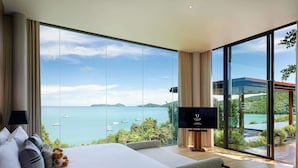 A modern hotel room with a large bed, a flat-screen TV, and a scenic ocean view. - V Villas Phuket - MGallery (Wichit)